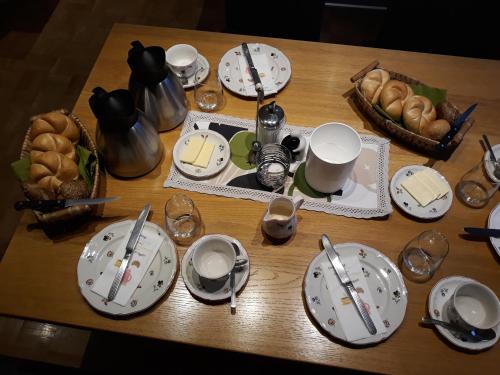 a table with plates and spoons and bread on it at Haus Silvia in Flachau