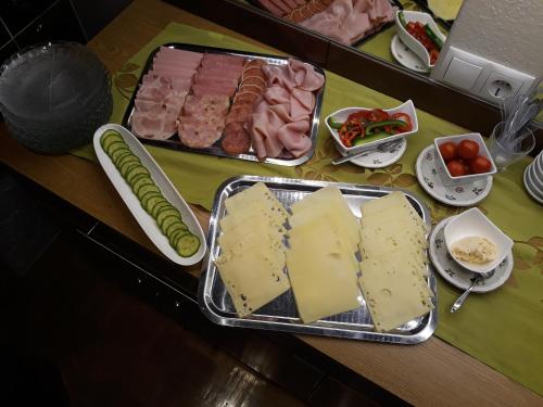 a table topped with cheese and meats and vegetables at Haus Silvia in Flachau