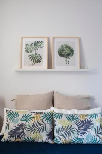 three framed drawings of plants on a white wall above a bed at Inmocyma Casa Cervino, La Coma de Alba-Benasque in Benasque