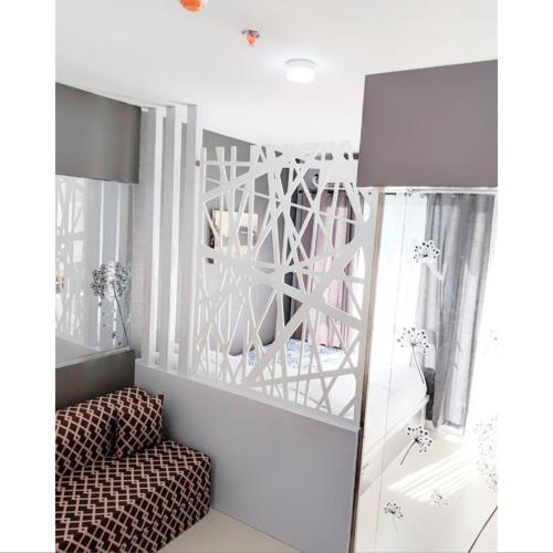een woonkamer met een stoel en een spiegel bij The Penn Room Tagaytay at Cool Suites in Tagaytay