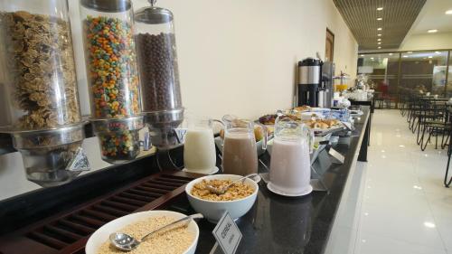 ein Buffet mit Schüsseln mit Müsli und Milch in der Unterkunft Hotel Diego de Almagro Santiago Centro in Santiago