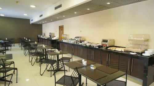 ein Restaurant mit Tischen und Stühlen in einem Raum in der Unterkunft Hotel Diego de Almagro Santiago Centro in Santiago