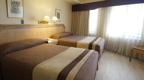 Ένα ή περισσότερα κρεβάτια σε δωμάτιο στο Hotel Diego de Almagro Santiago Centro