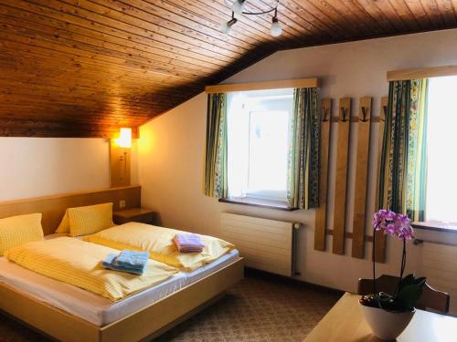 a bedroom with a bed with yellow sheets and a window at Garni-Appartement Collina in Samnaun