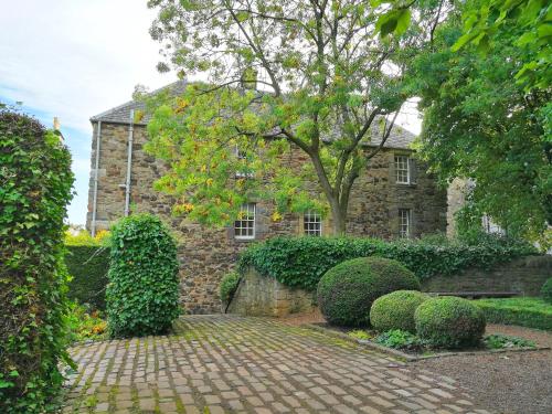a stone house with a brick walkway in front of it at Cadell House Apt - Royal Mile in Edinburgh
