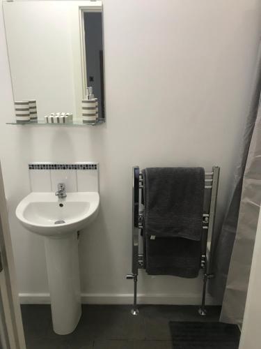 a white bathroom with a sink and a mirror at The Bungalow in Leeds