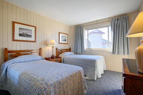 a hotel room with two beds and a window at Outer Banks Beach Club in Kill Devil Hills