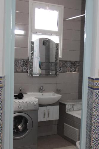 a bathroom with a washing machine and a sink at City Apartment sur le port de Mahdia Free Wifi in Mahdia
