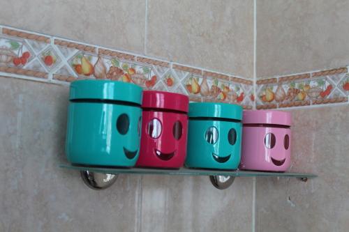 four hello kitty buckets on a shelf in a bathroom at City Apartment sur le port de Mahdia Free Wifi in Mahdia