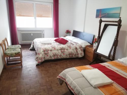 a bedroom with two beds and a mirror and a chair at Venice Holiday in Marghera
