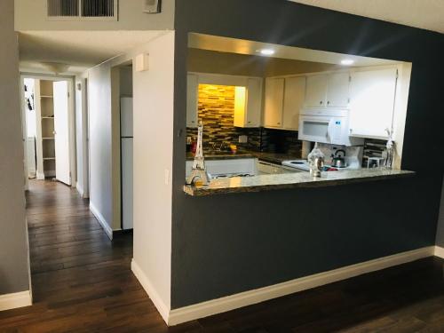 a kitchen with white cabinets and a black wall at Amazing Spare Bedroom in Shared 2/B Condo behind Convention Center in Las Vegas