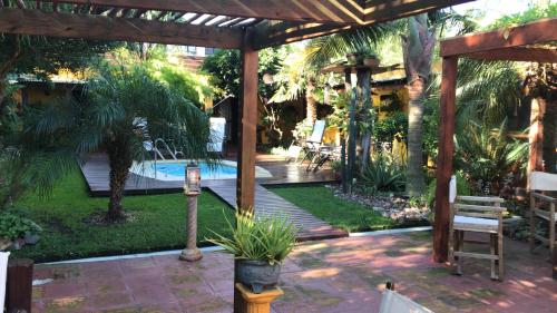 un patio con una pérgola de madera y una piscina en El Bambu, en Ciudad de la Costa