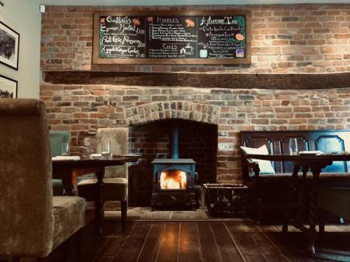 a brick wall with a fireplace in a restaurant at The Lion in Leintwardine