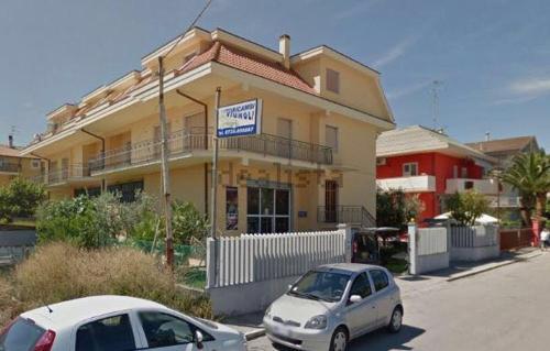 two cars parked in front of a building at Sun Beach in San Benedetto del Tronto