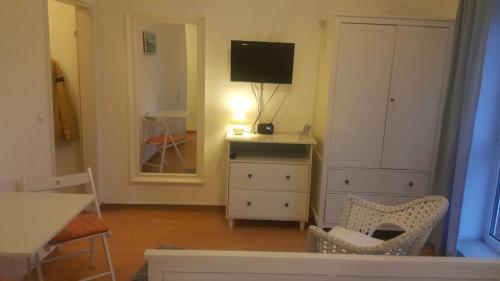 a living room with a television and a table and chairs at Appartement in Glinde in Glinde