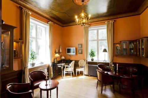 un salon aux murs orange et une salle à manger dans l'établissement Liselund Ny Slot Hotel, à Borre