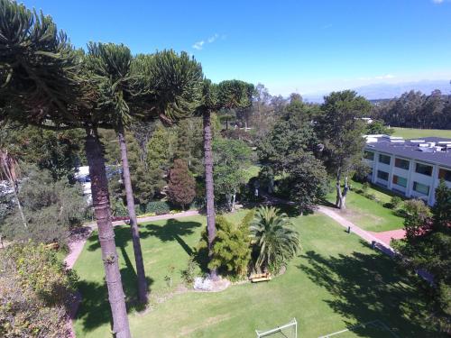 an aerial view of a park with palm trees and a building at San Jose de Puembo Quito Airport, an Ascend Collection Hotel in Puembo