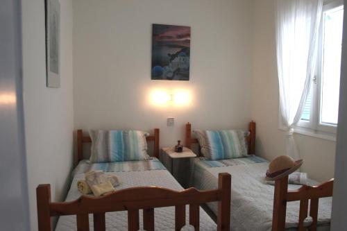 a bedroom with two twin beds and a table at Siviri, the beautiful sunset in Siviri