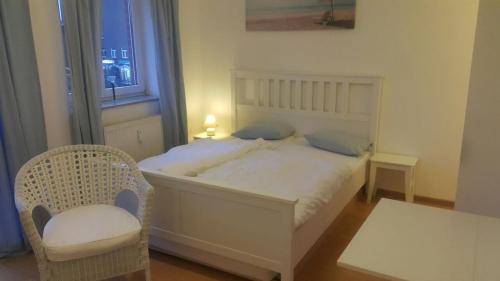 a bedroom with a white bed and a chair at Appartement in Glinde in Glinde