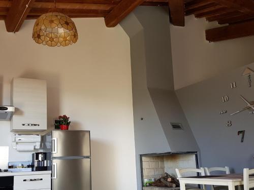 a kitchen with a stainless steel refrigerator in a room at Vicus House in Viciomaggio