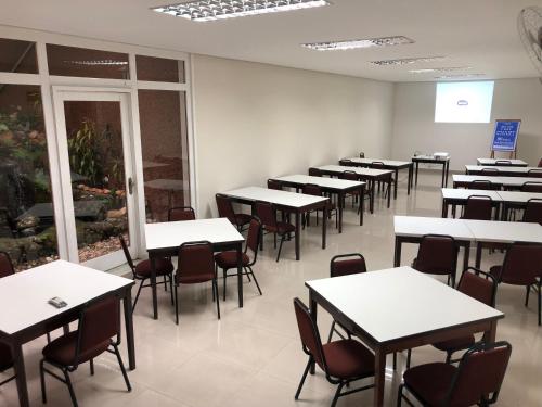 une salle de classe vide avec des tables et des chaises dans l'établissement Regis Hotel II, à Registro