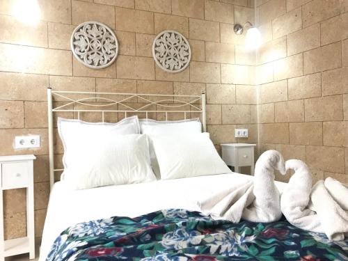 deux animaux farcis sont assis sur un lit dans l'établissement Apartamento !!VIVE JEREZ!!, à Jerez de la Frontera