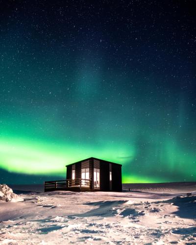 a cabin under the northern lights under the stars at Afternoon Cottages in Hella