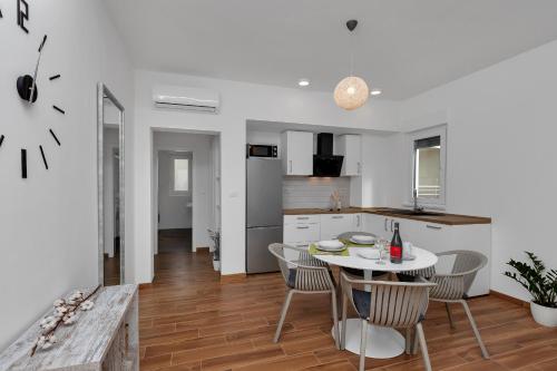 a kitchen and dining room with a table and chairs at Emilia Lofts in Tučepi