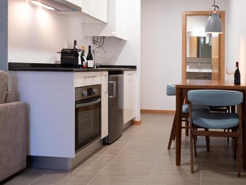 a kitchen with a counter and a table in a room at Bemyguest - Loft Guest House Jardim das Mães Charming in Viseu