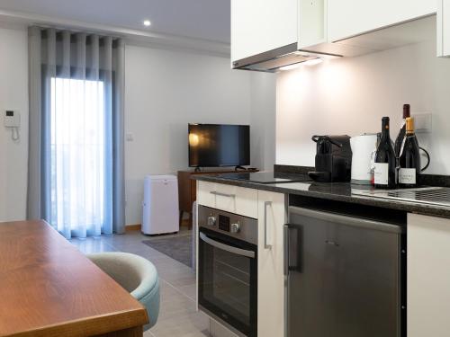 a kitchen with a table and a counter top at Bemyguest - Loft Guest House Jardim das Mães Charming in Viseu