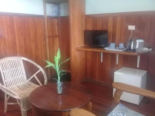 Habitación con mesa, sillas y TV. en Rekona Lodge en Gizo