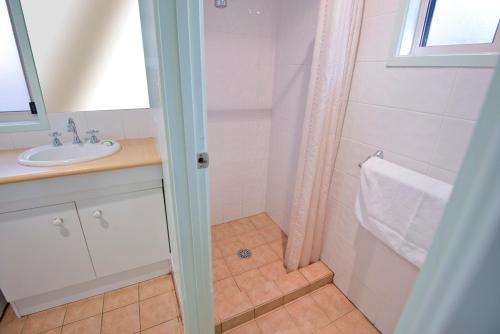 a bathroom with a sink, toilet and tub at Kianinny Bush Cottages in Tathra