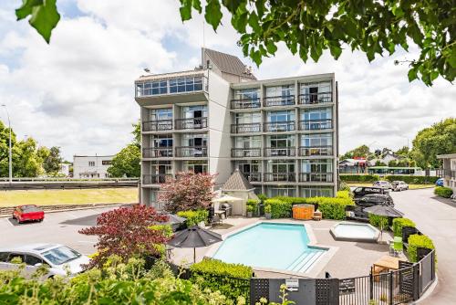 an apartment building with a pool and a parking lot at Heartland Ambassador Hotel Hamilton in Hamilton