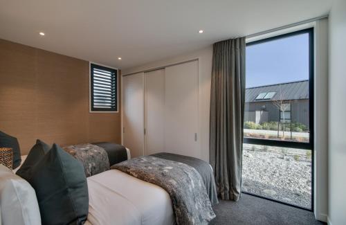 a hotel room with two beds and a large window at 4 Stockyard Lane by Sotheby's Luxury Rental Homes in Queenstown