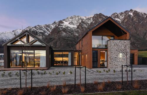 a modern house with mountains in the background at 4 Stockyard Lane by Sotheby's Luxury Rental Homes in Queenstown