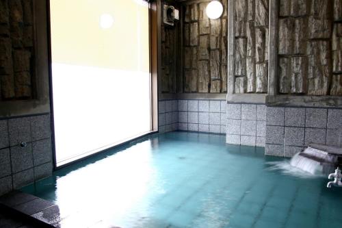 una piscina de agua en una habitación con ventana en Hotel Route-Inn Court Kofu, en Kofu