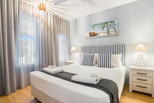パーム・コーブにあるTropical Unit with Private Fenced Garden Close to The Beach 4の大きな白いベッドと窓のある寝室