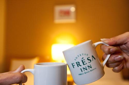 a person holding a coffee mug with the words drifting fresh istg at Sotetsu Fresa Inn Tokyo Tamachi in Tokyo