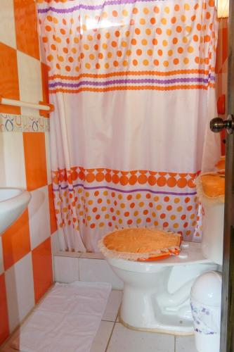 a bathroom with a toilet with a shower curtain at Mindoxtrem Birds in Mindo