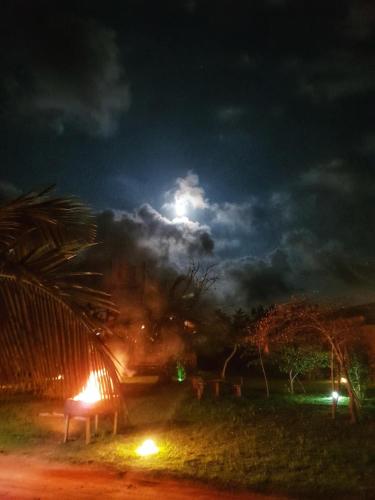 a night time picture of a fire in a field at Yala Peace Cottages in Tissamaharama
