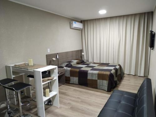 a bedroom with a bed and a table and a desk at Departamento Casa del Parque in Necochea