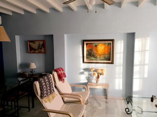 Una sala de estar con dos sillas y una mesa. en Los Bancales, en Frigiliana