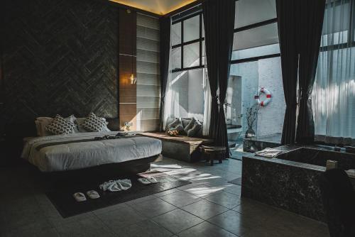 a bedroom with a bed and a bath tub and a tub at Arun Dara Villa in Chiang Mai