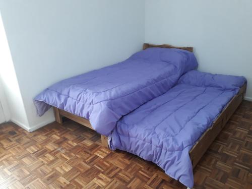 1 cama con edredón púrpura en una habitación en Aquí Departamentos en Buenos Aires