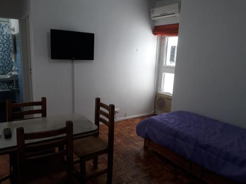 1 dormitorio con 1 cama, 1 mesa, 1 cama y TV en Aquí Departamentos en Buenos Aires