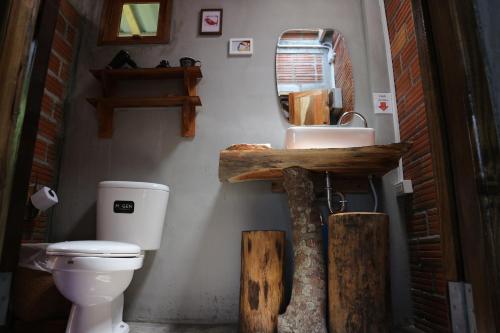 een badkamer met een toilet, een wastafel en een spiegel bij BaanRaiChayKhaoFarmStay in Nakhon Si Thammarat