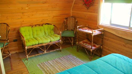 a living room with two chairs and a couch at La Cabaña de Piedra in Las Trancas