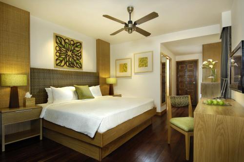 a bedroom with a bed and a desk with a fan at Berjaya Langkawi Resort in Pantai Kok