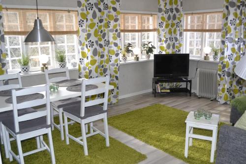 uma sala de estar com uma mesa e cadeiras e uma televisão em Ekeliden B&B em Ulricehamn