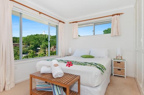 a white bedroom with a bed and a window at WategosRent in Byron Bay